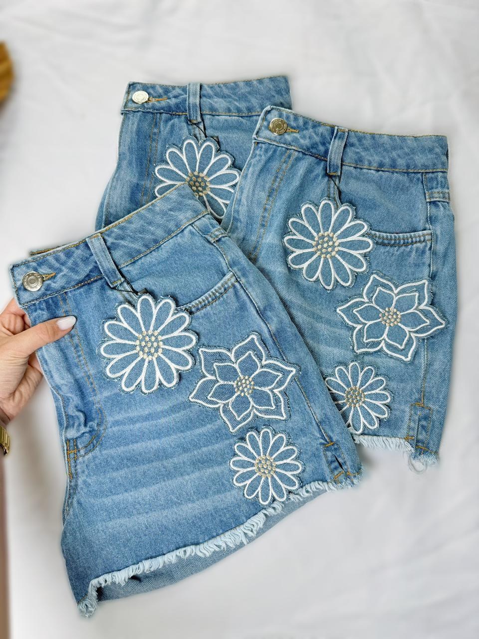 Short Jeans Feminino 3 Flores Bordadas Aplique Cintura Alta Desfiado com Bolso