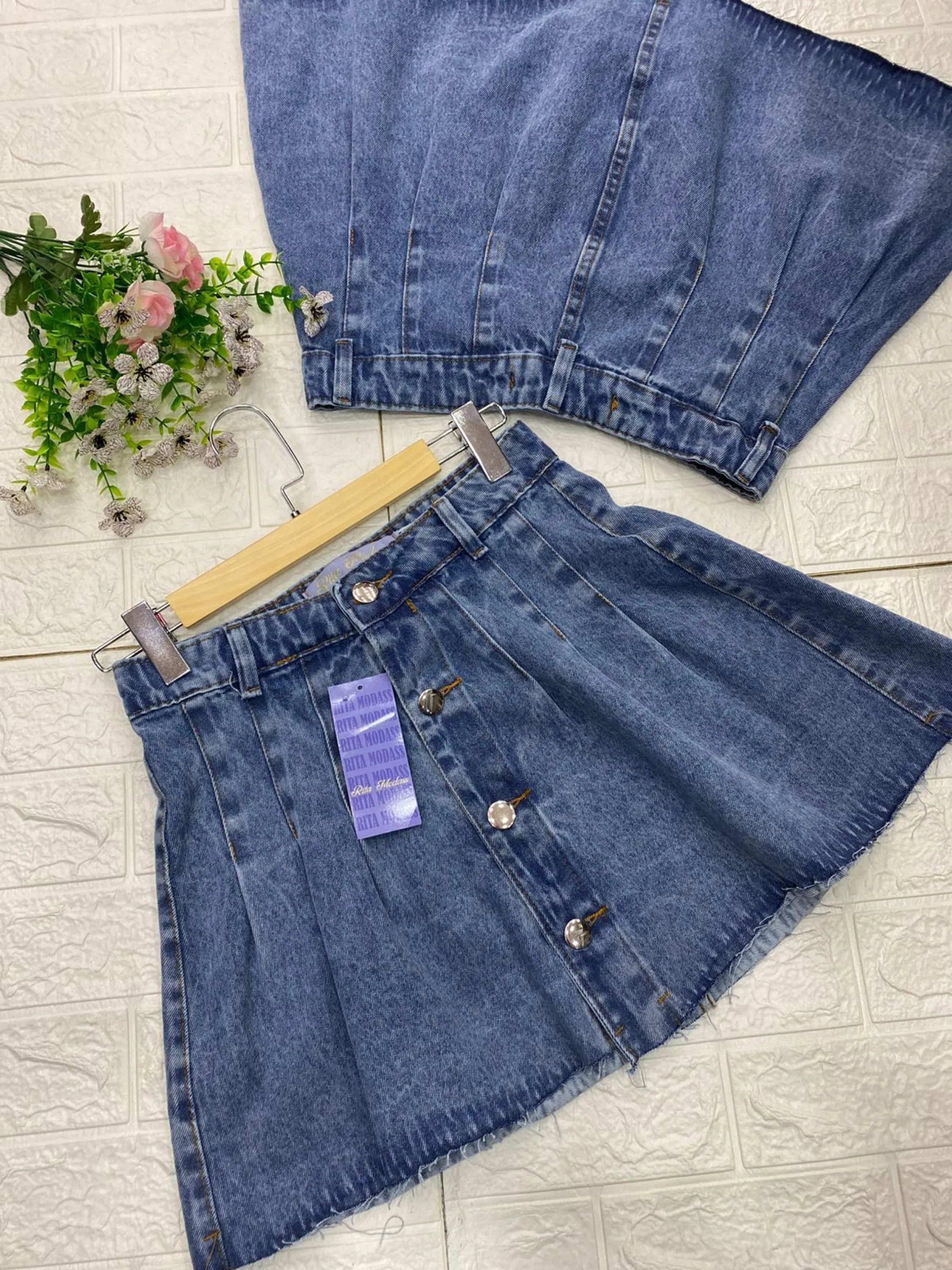 Saia jeans curta plizada com fecho botões