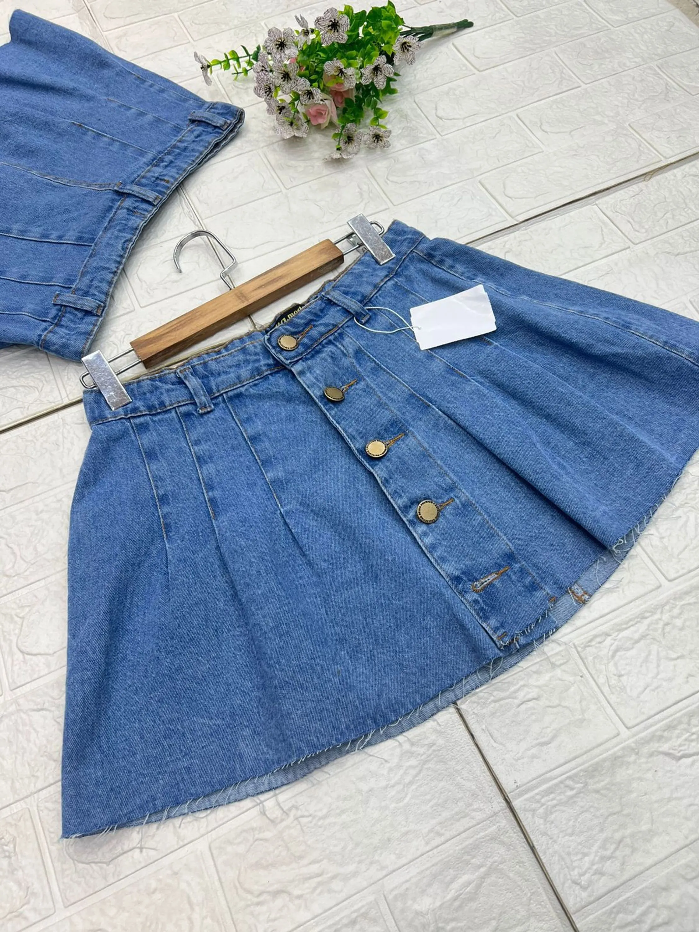 Saia jeans curta plissada botões dourado discreto