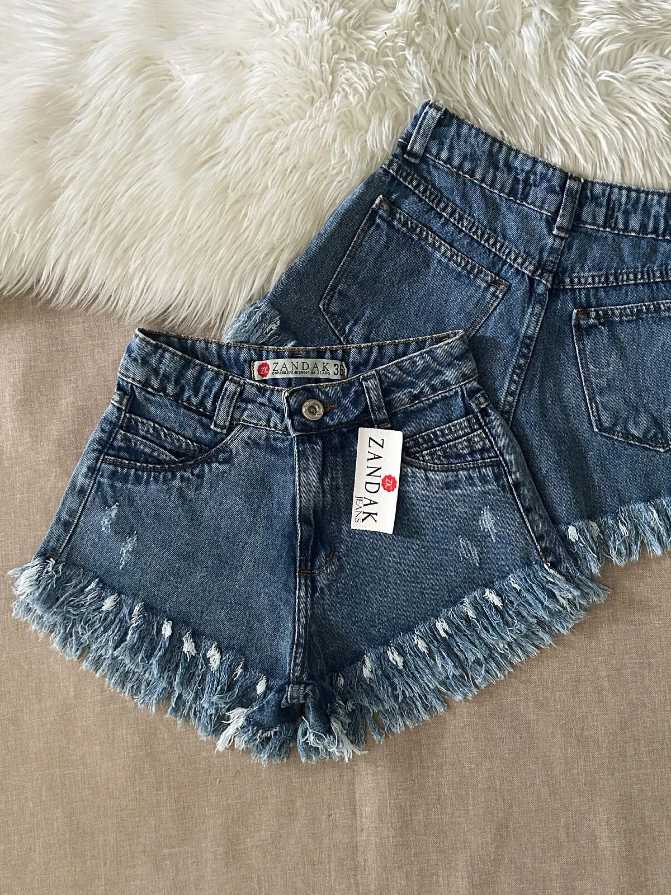 Short jeans feminina escura barra desfiada