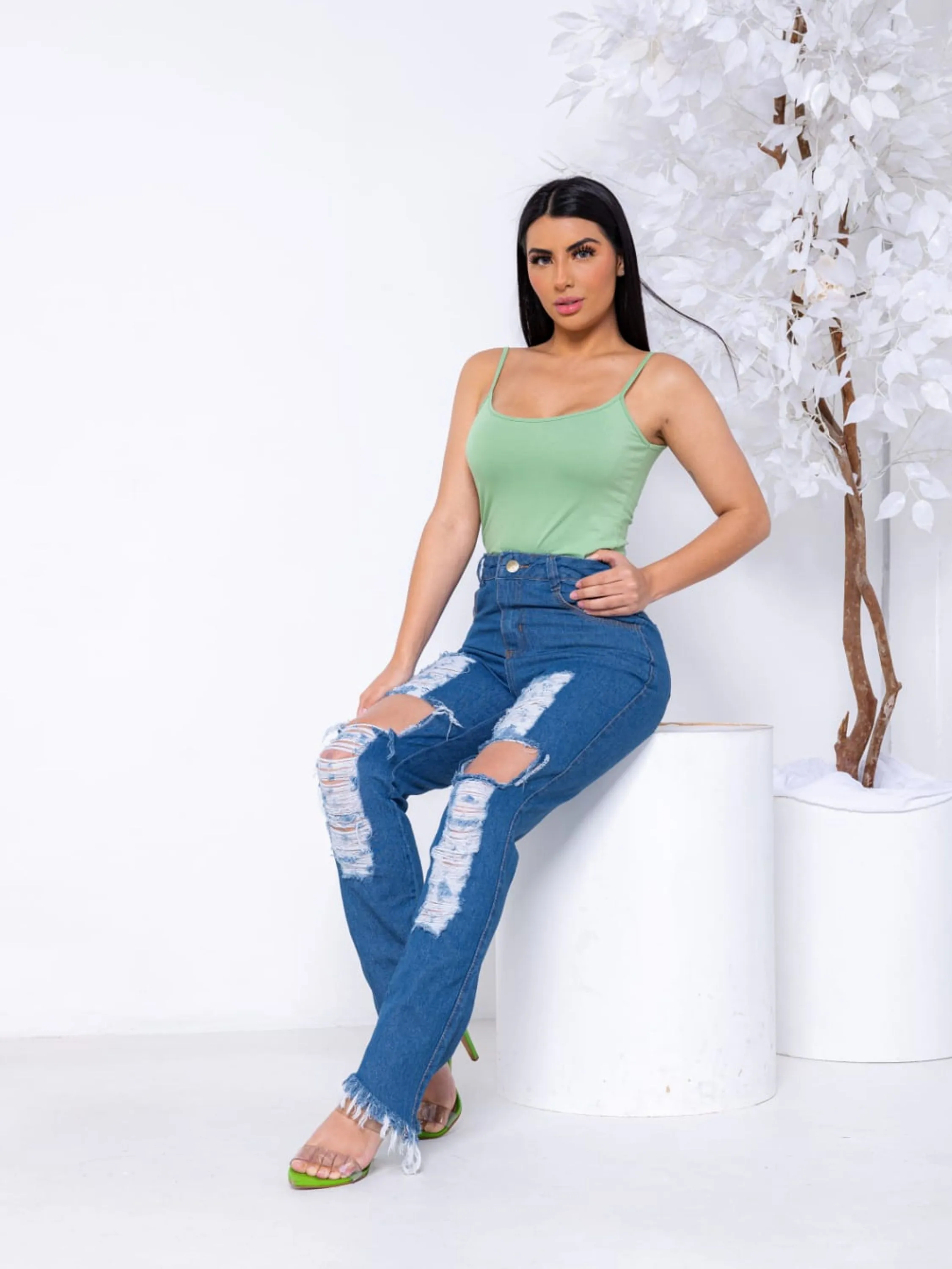 Calça jeans feminina lavagem media 100% algodão com detalhe rasgado na perna e barra desfiada