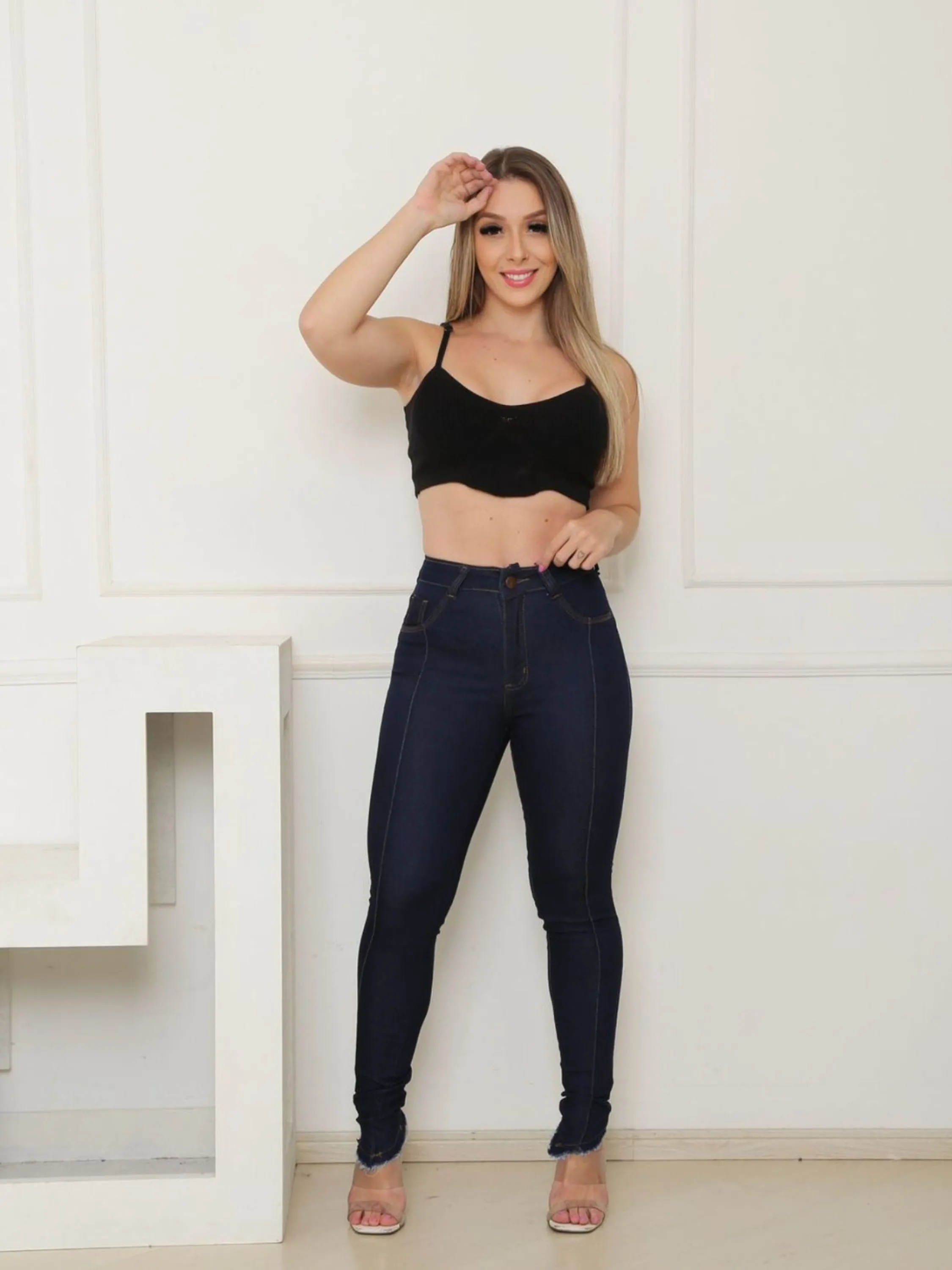 calça jeans skinny lavagem escura com elastano e detalhe de barra desfiada