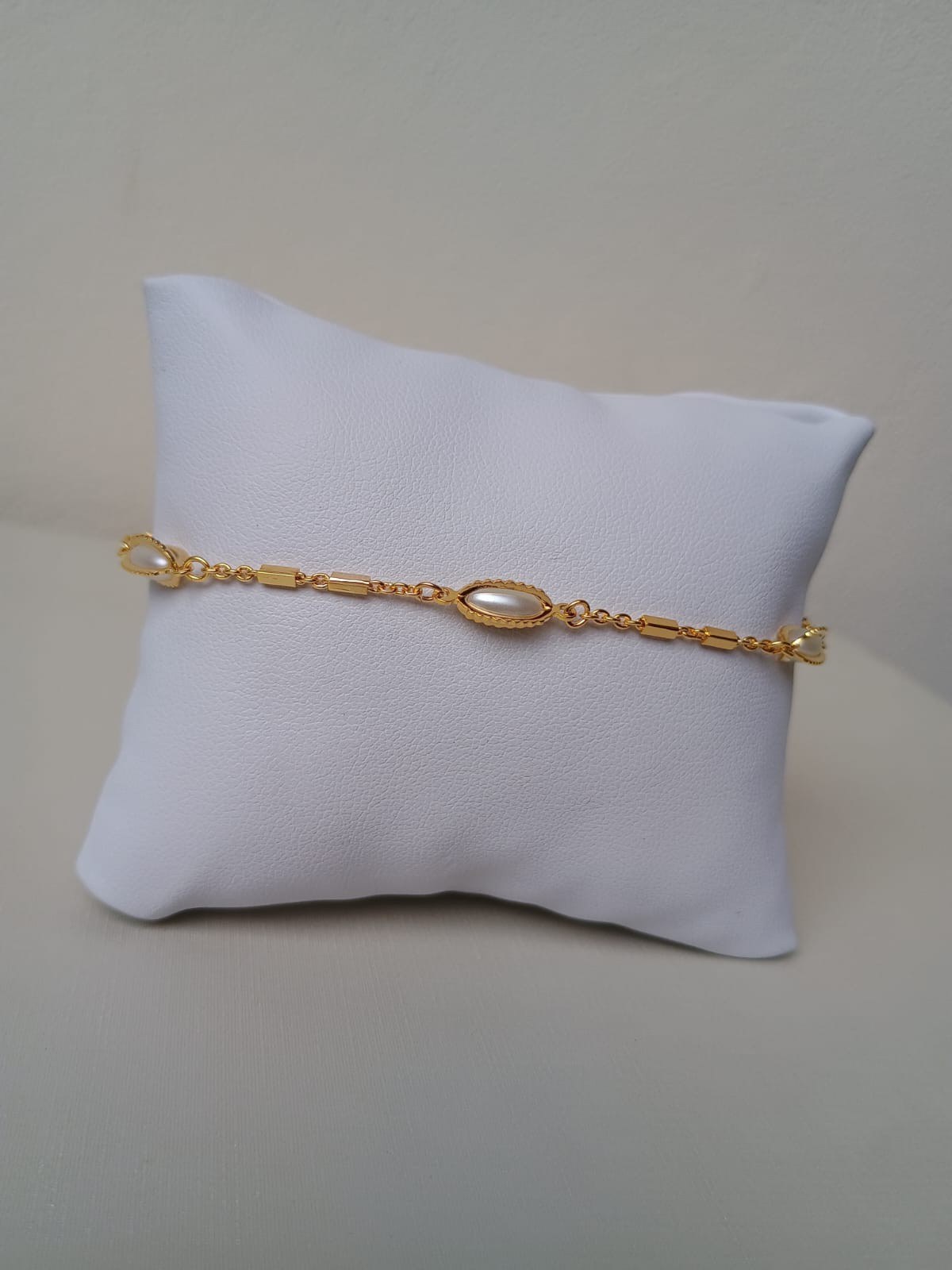 Pulseira com pérolas ovais e detalhes dourados