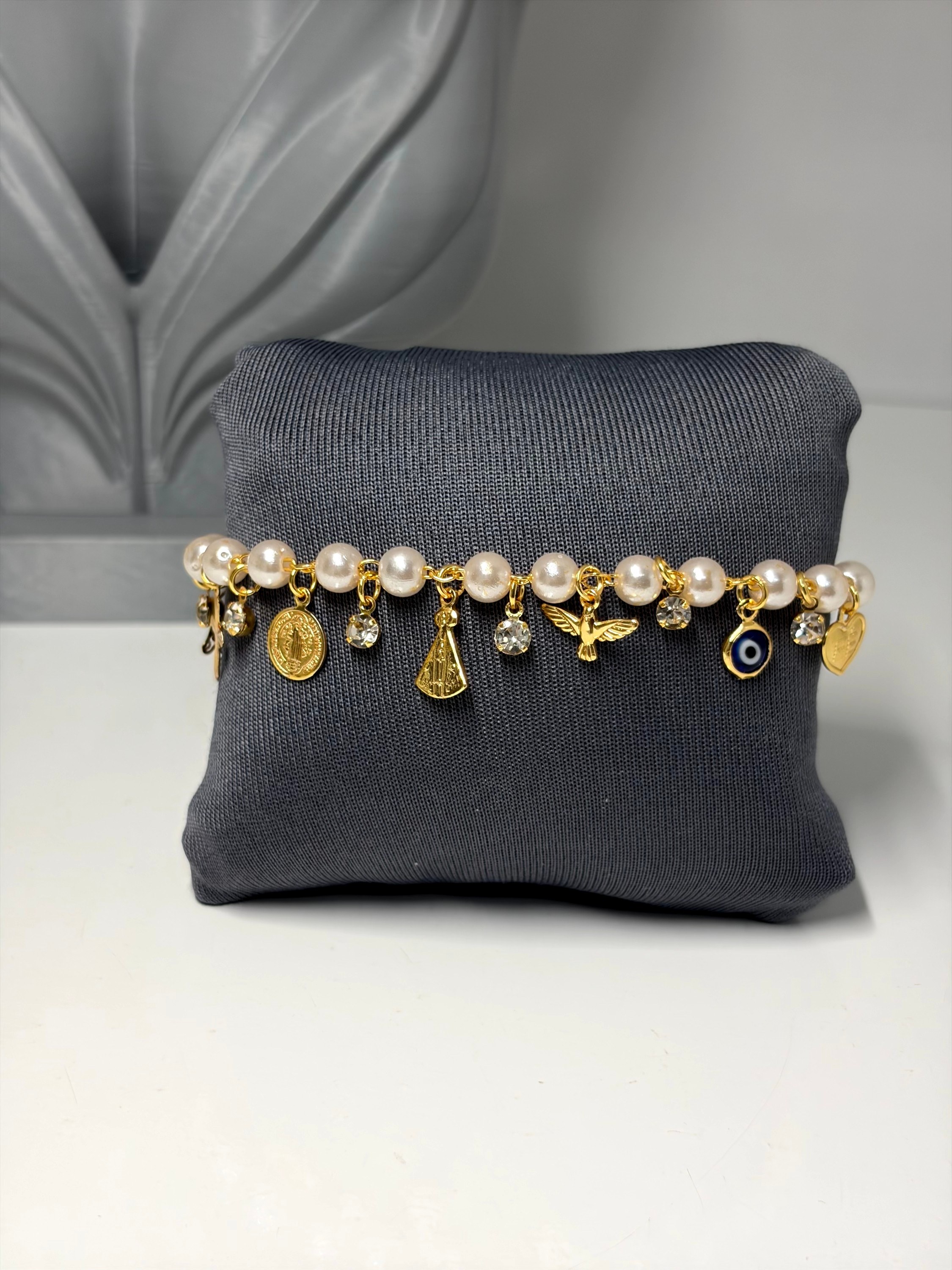 Pulseira com bolinhas e pingentes religiosos