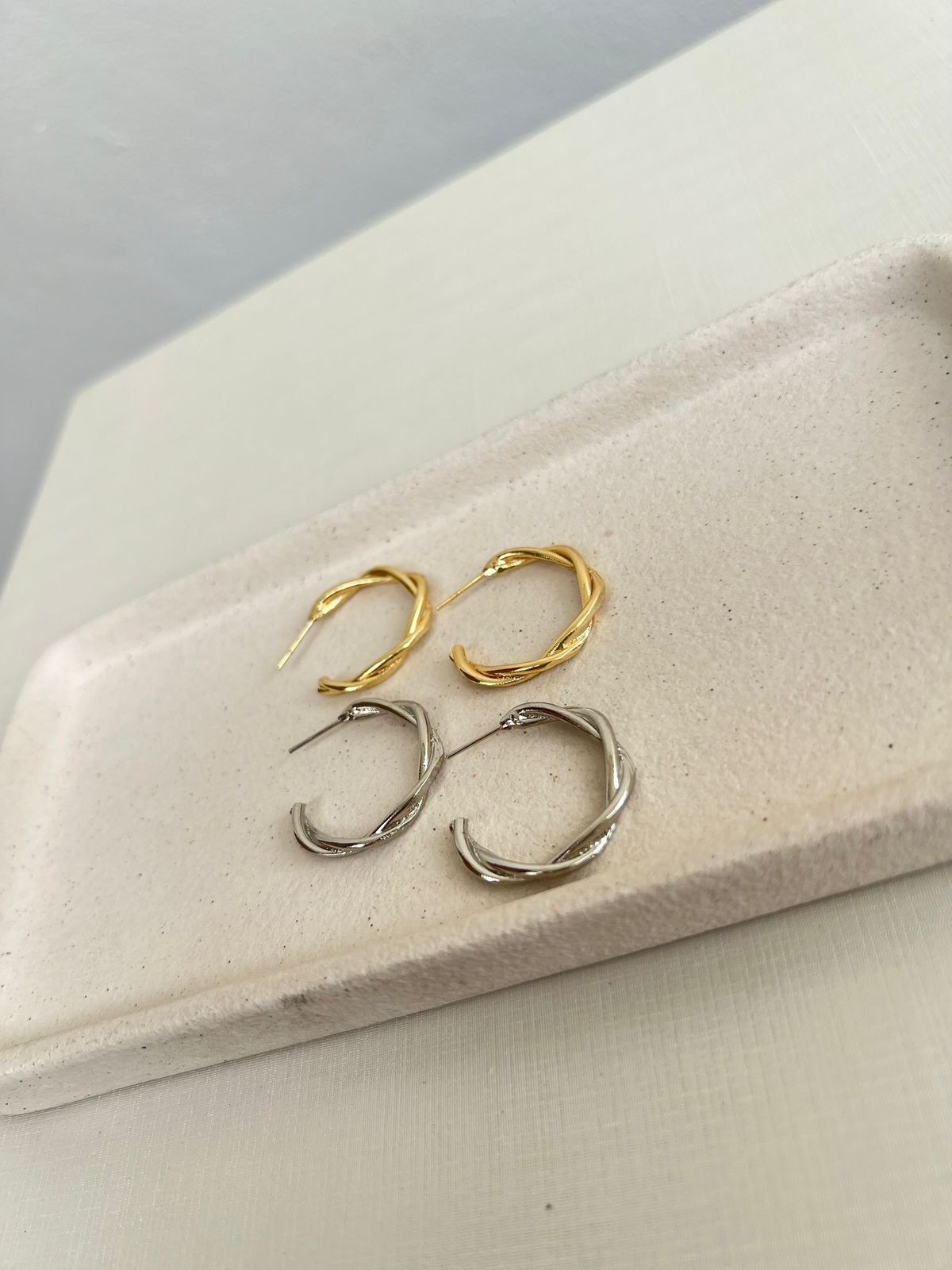 Brincos de argola cruzada