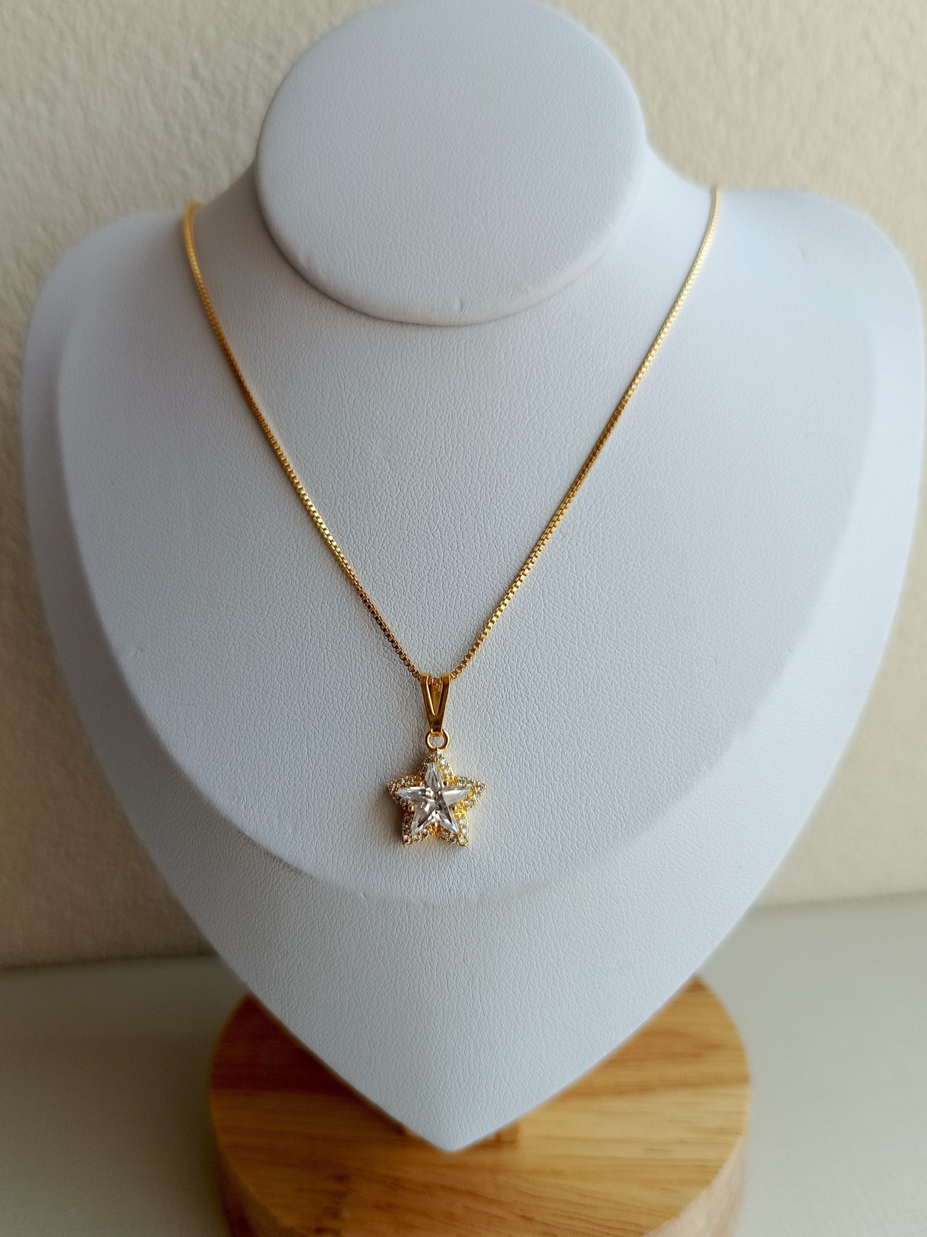 Colar dourado com pingente de estrela de zircônia
