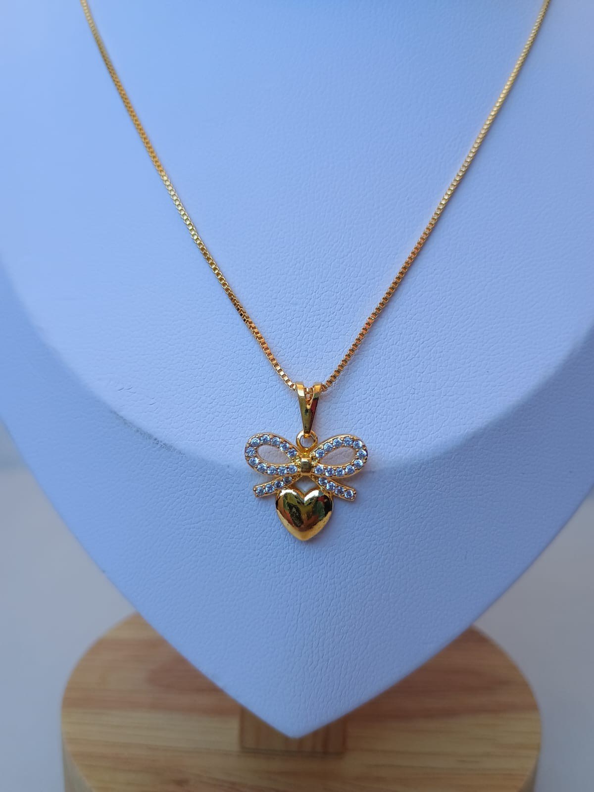 Colar delicado com um coração e um laço