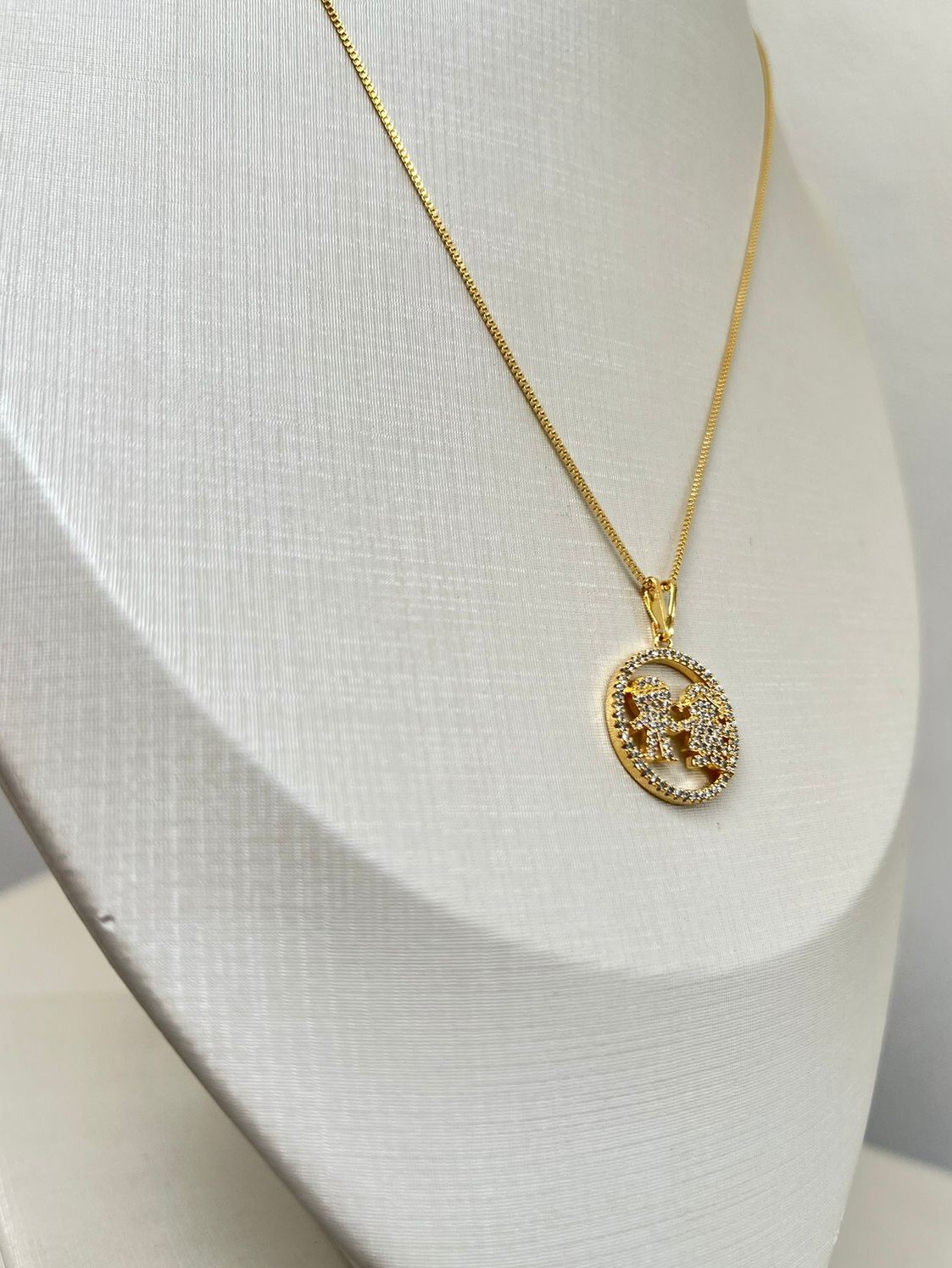 Colar dourado com pingente de filhos com zircônia