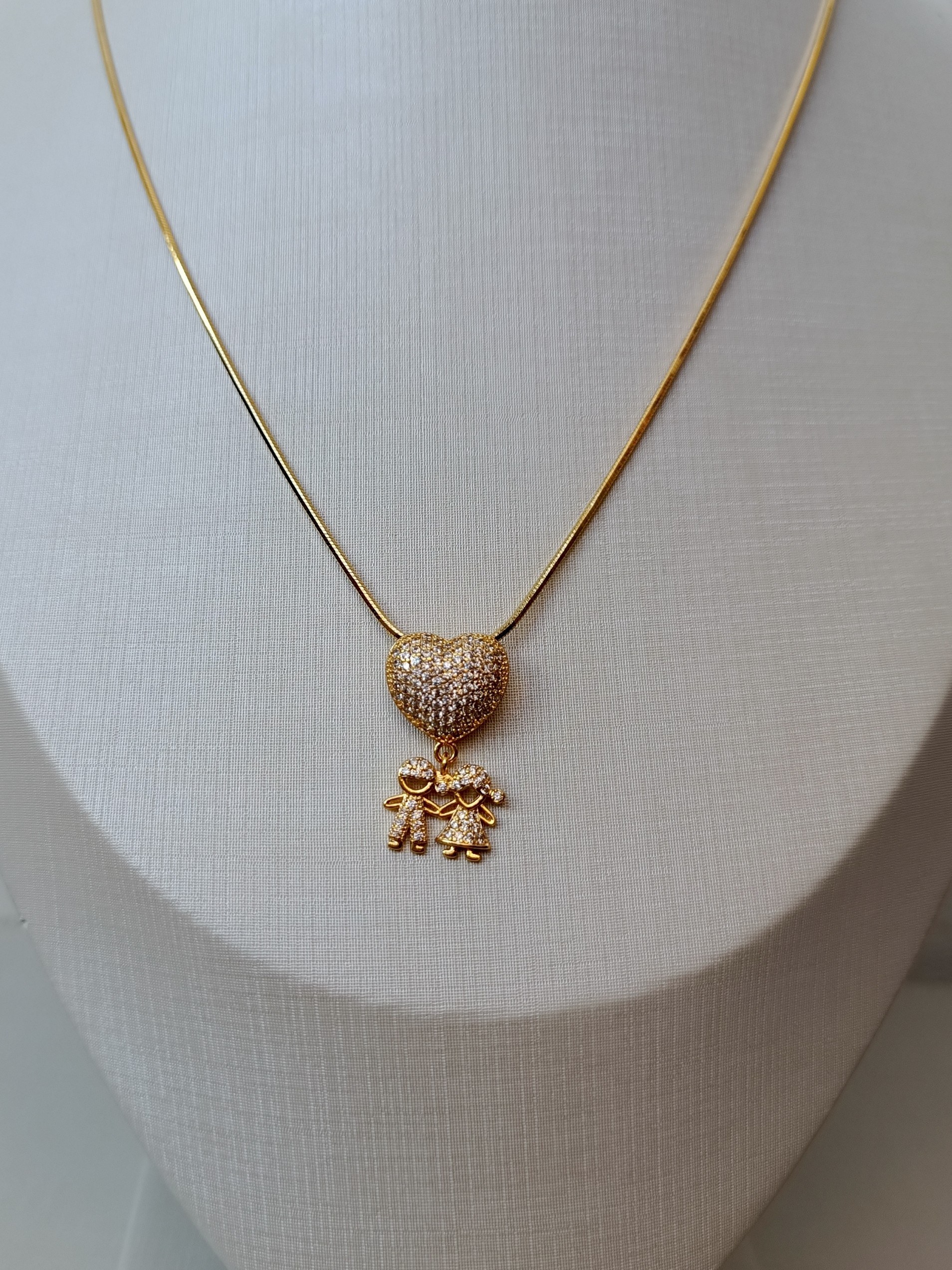 Colar dourado com pingente de coração e casal de filhos