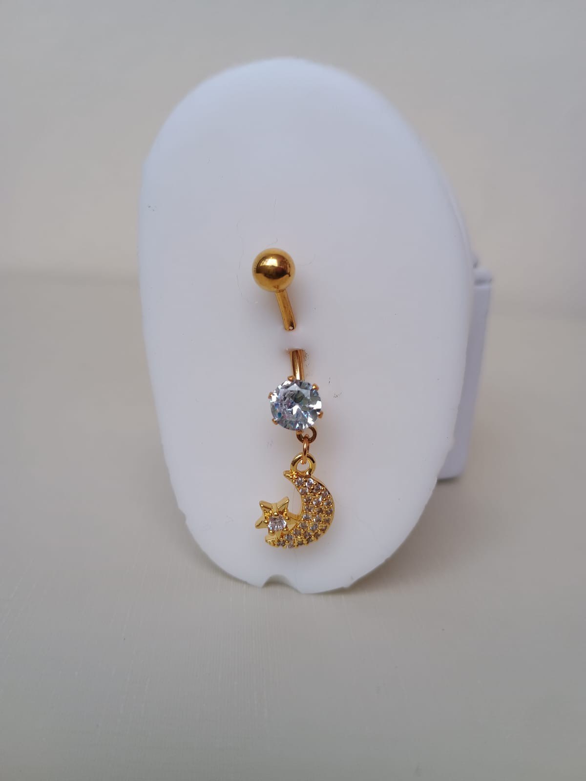 Piercing com meia lua e estrela cravejada com zircônias